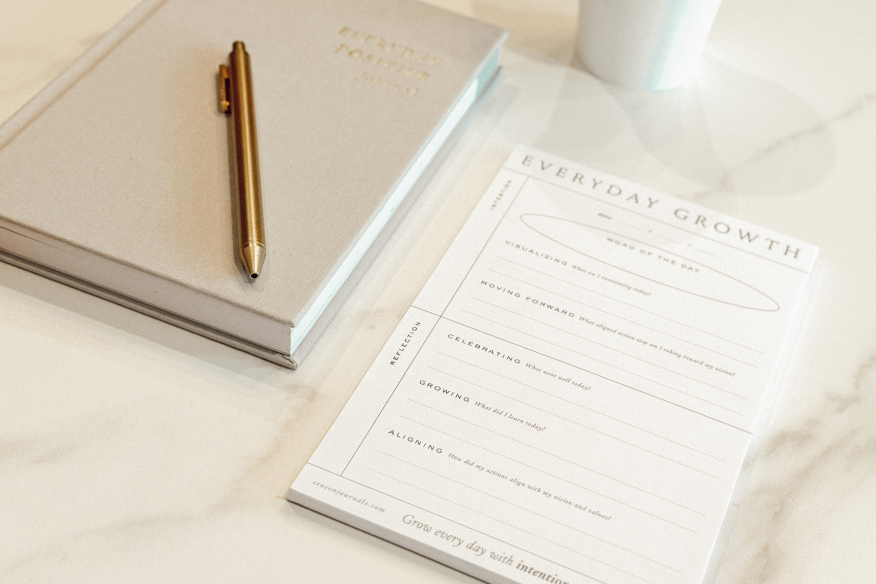 Everyday Positive Journal, Pen, Everyday Growth Notepad on marble table with cup of coffee