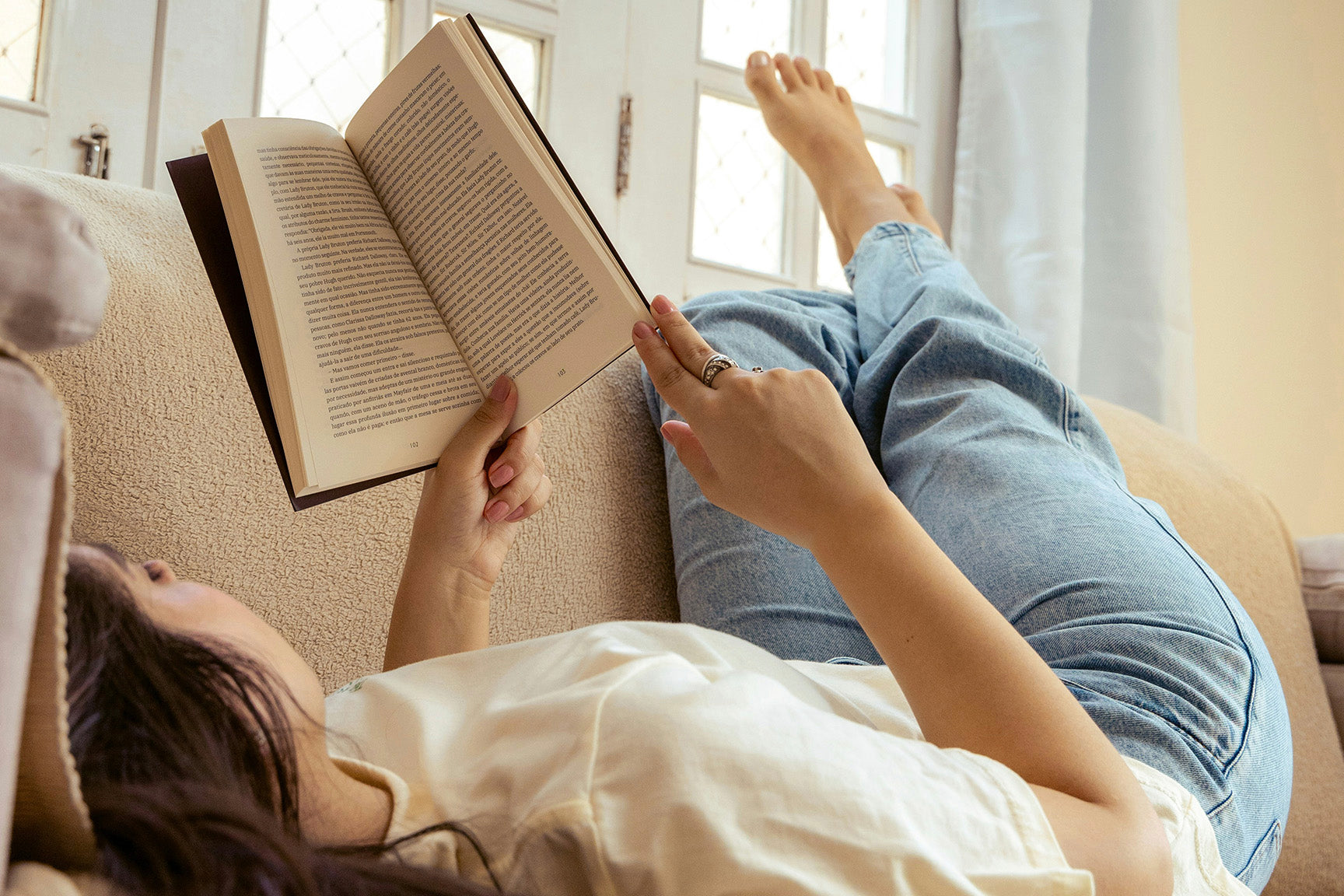 woman reading a book on the couch