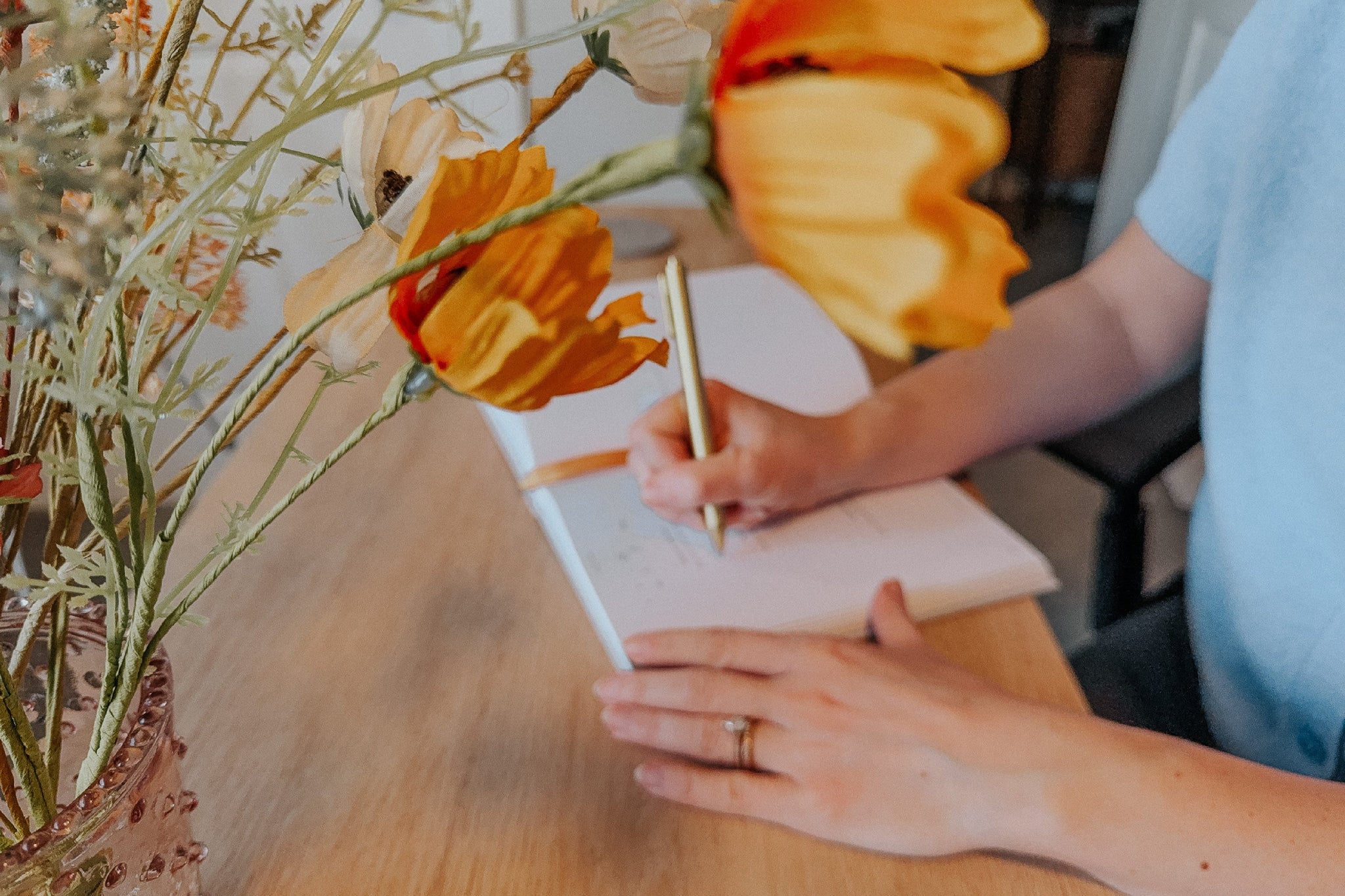 woman journaling with flowers in the foreground