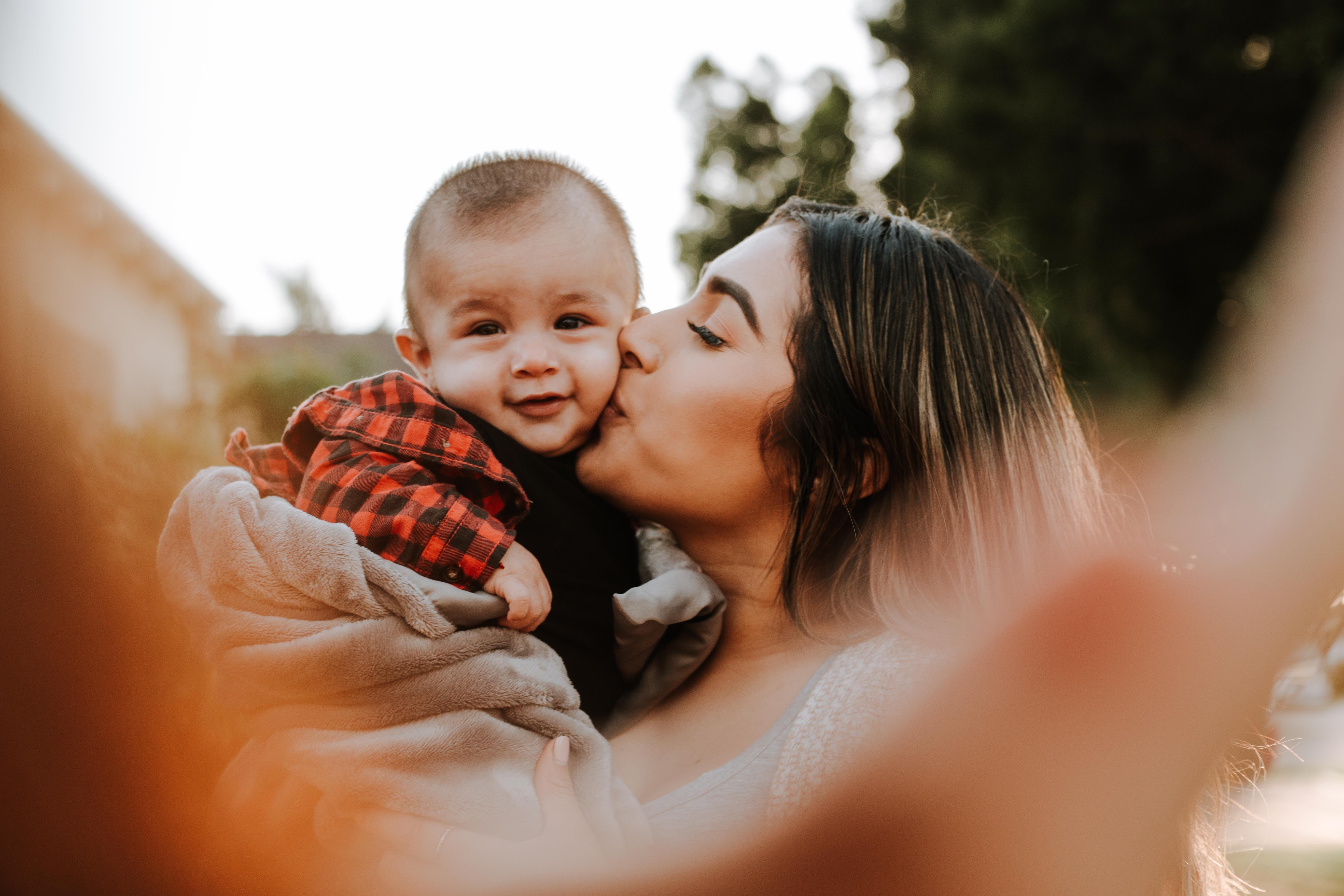 Mother kissing young child
