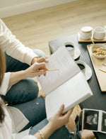 Load image into Gallery viewer, Couple writing in the Pregnancy Journal together with sonogram in the background