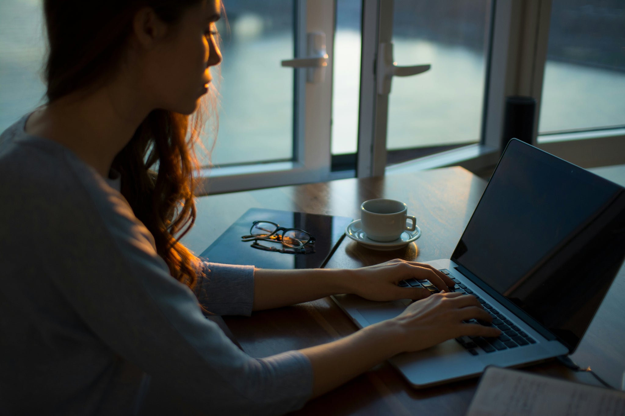 woman on computer in early morning light