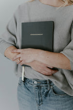 Load image into Gallery viewer, Woman holding dark grey engagement journal close to her chest
