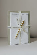 Load image into Gallery viewer, Side view of workbook, notepad, and pen tied together with ribbon
