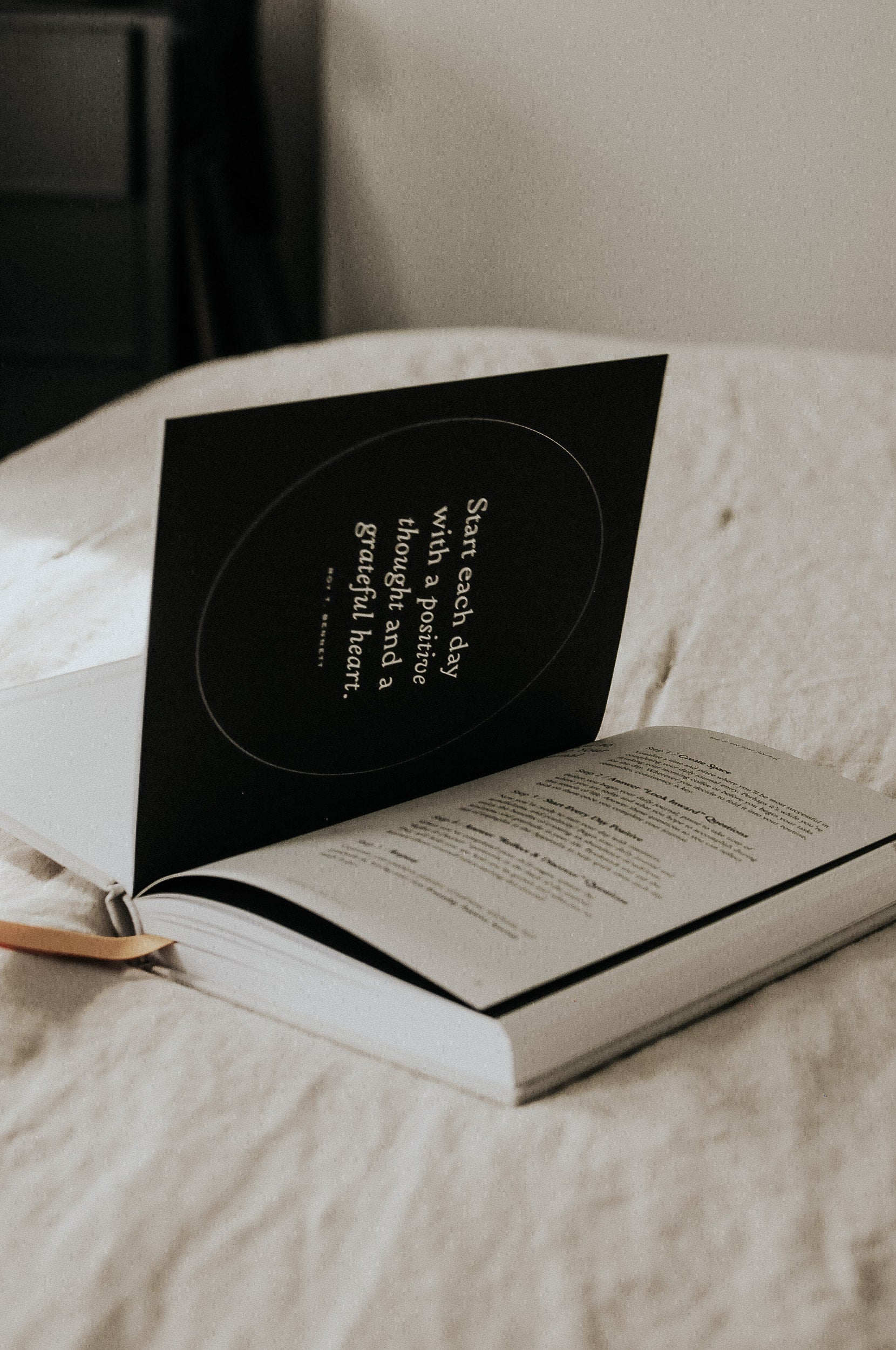 Everyday Positive Journal on linen blanket in bedroom