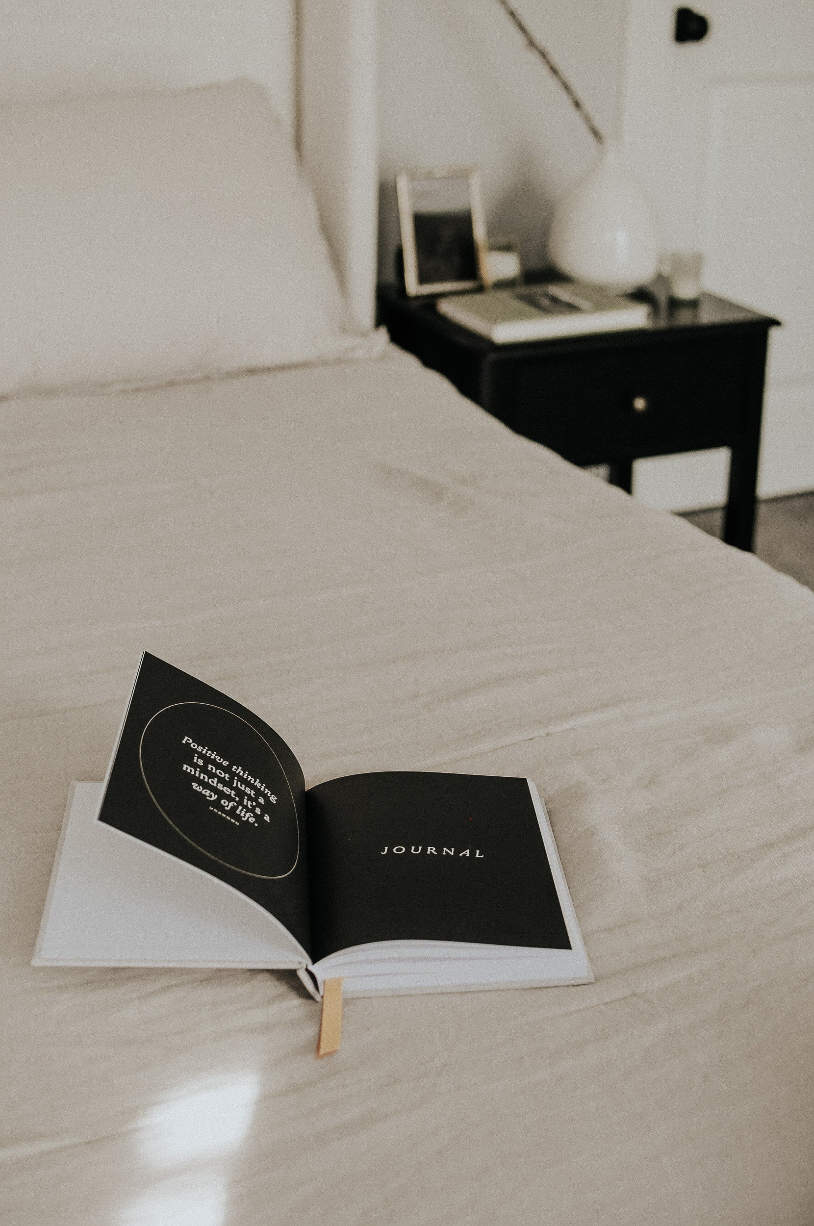 Everyday Positive Journal on linen blanket in bedroom