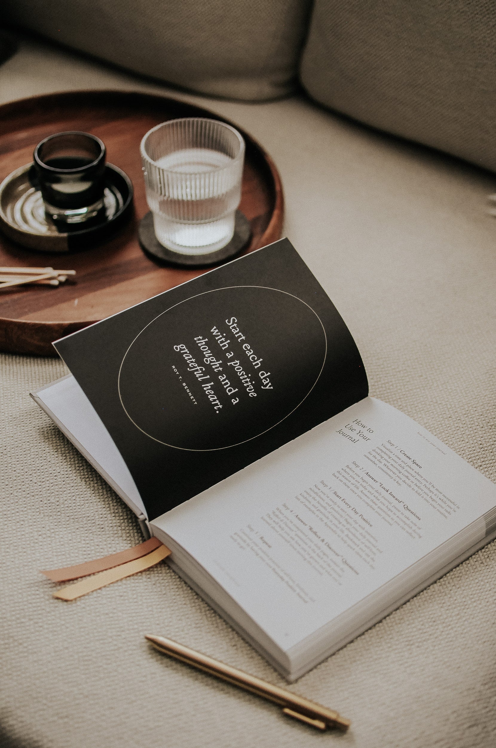 Everyday Positive Journal on cozy couch with pen