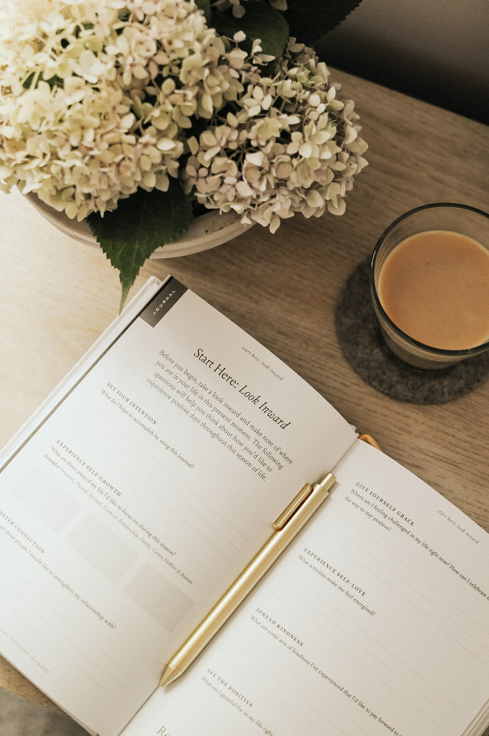 Everyday Positive Journal open on desk with coffee and flowers
