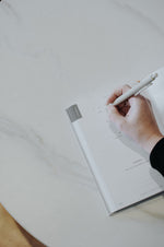 Load image into Gallery viewer, Woman writing in the Everyday Positive Journal in a cafe

