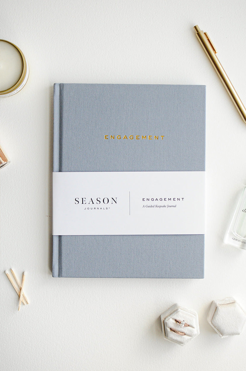 Engagement Journal on white background with candle, pen, and rings