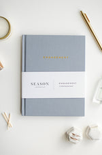 Load image into Gallery viewer, Engagement Journal on white background with candle, pen, and rings
