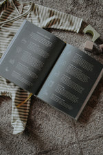 Load image into Gallery viewer, Pregnancy Journal open to Postpartum Self-Care page with baby outfit and blocks in the background
