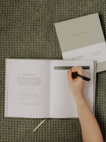 Load image into Gallery viewer, Mom-to-be writing in the Pregnancy Journal on green blanket

